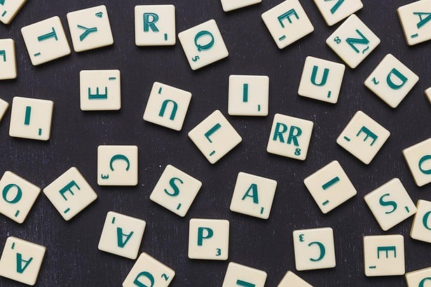 close up scrabble letters against black background.