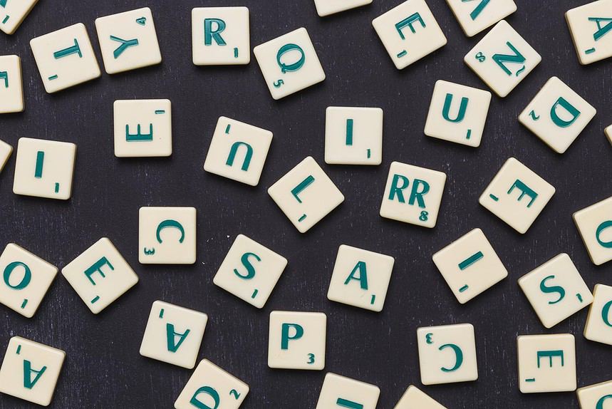 close up scrabble letters against black background.